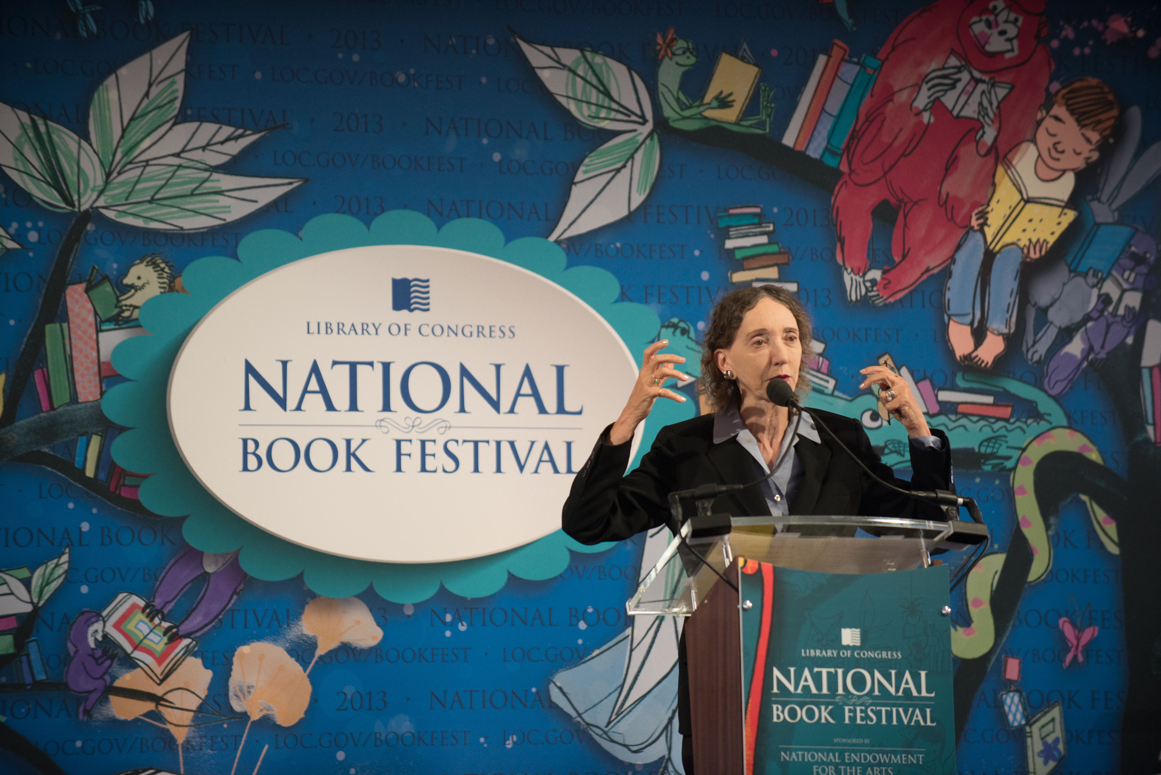 Joyce Carol Oates on stage talking behind a podium.