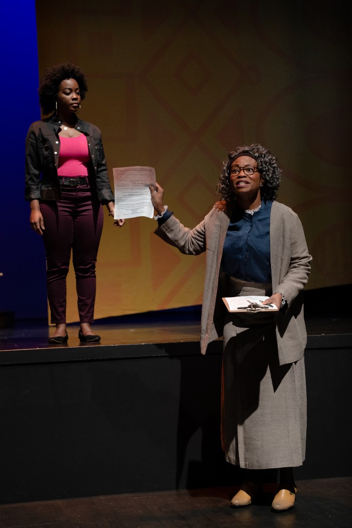 A scene from Lawbreakers! An actress asks a young audience whether anyone needs a voter registration card