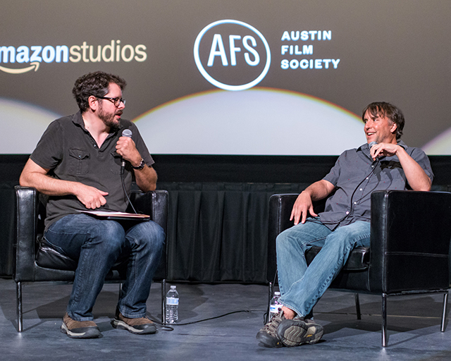 A man interviewing another man onstage