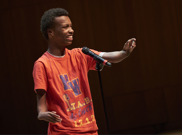 close-up of a young man performing his poetry on a stage