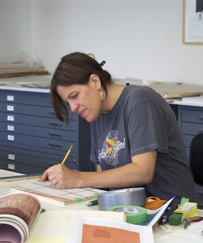 artist Marie Watt sits working on an art project at a table