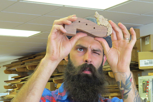 A man examines a piece of a dulcimer