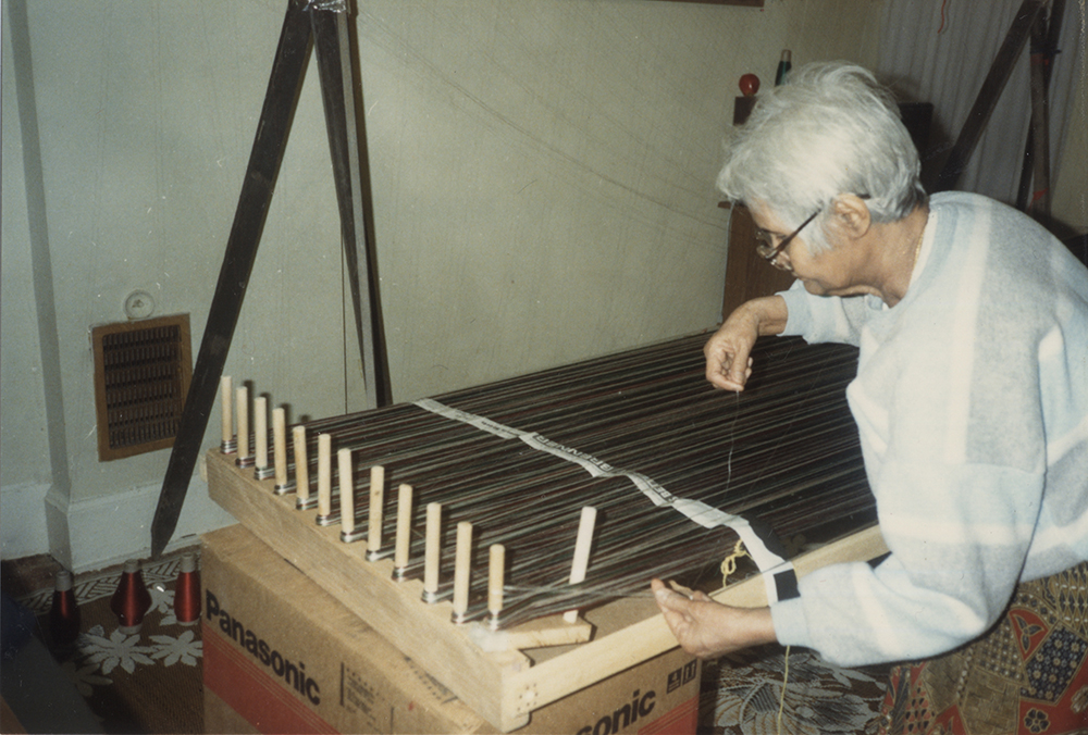 Woman working a loom. 