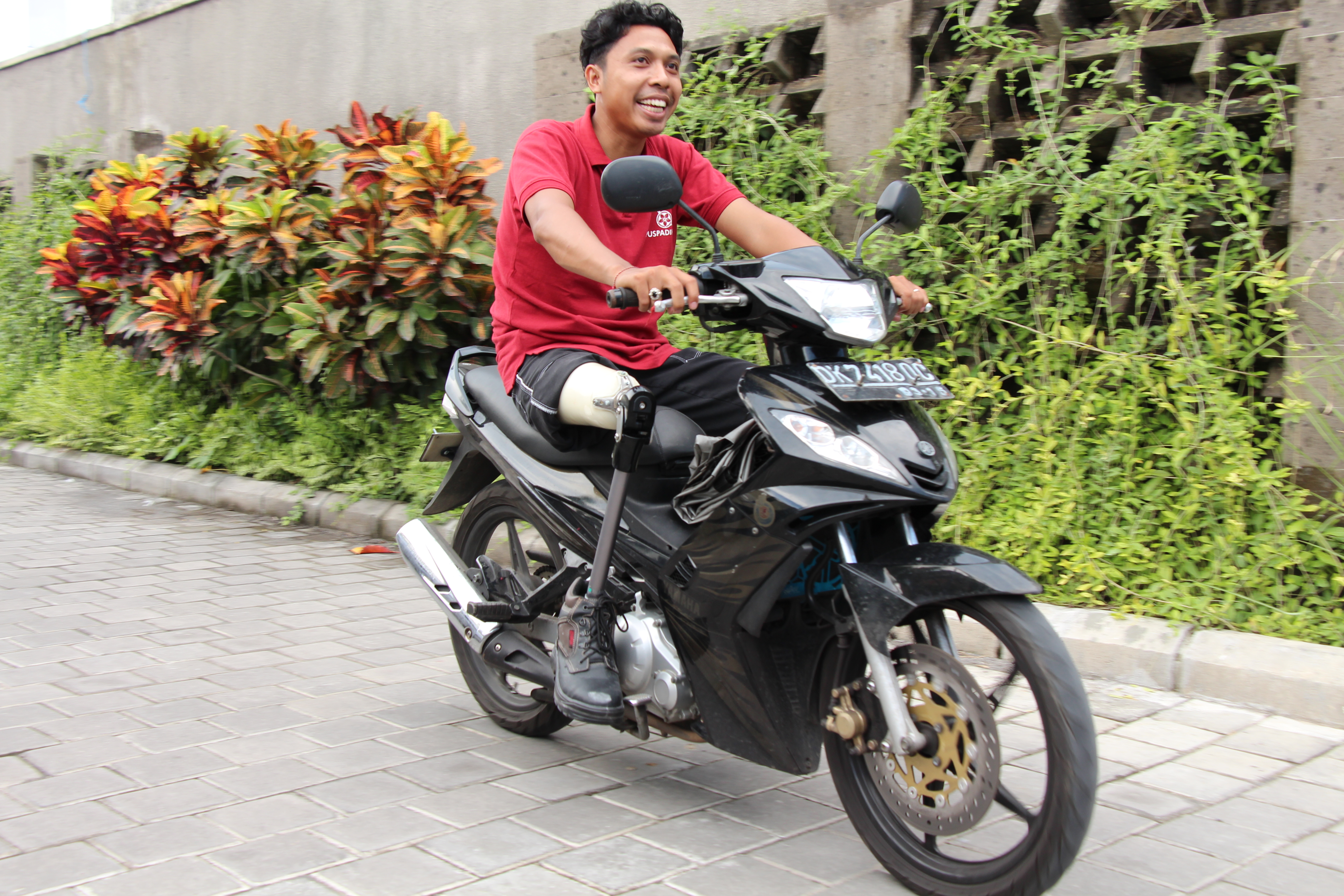 Man with prosthetic leg riding a motorbike.