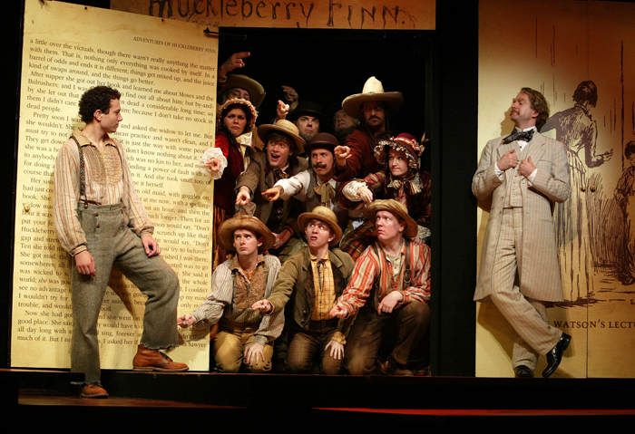 Deaf West Theatre’s production of Big River A cast dressed in 1800s clothing in front of a backdrop of Huckleberry Finn.