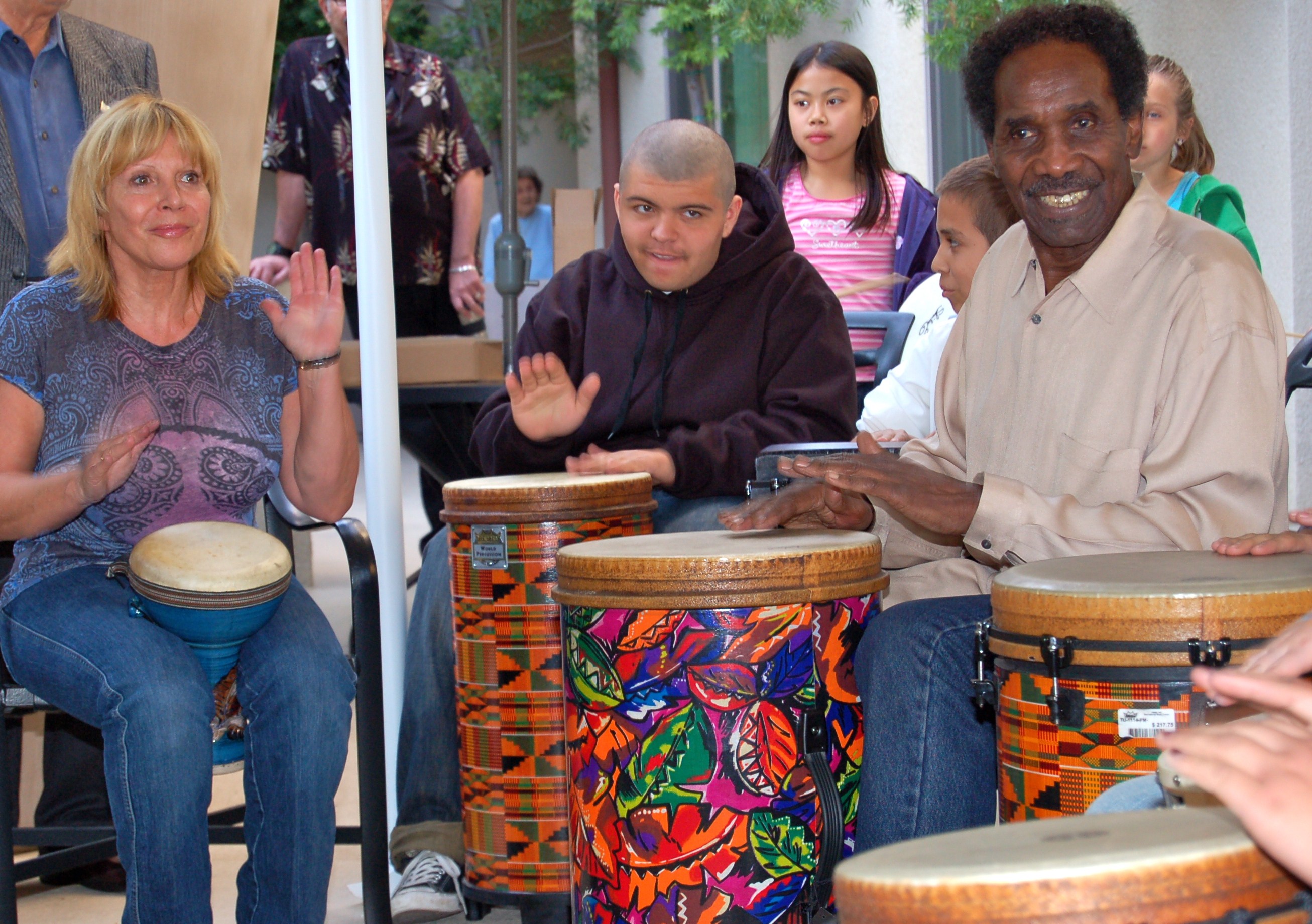 Intergenerational group playing drums.