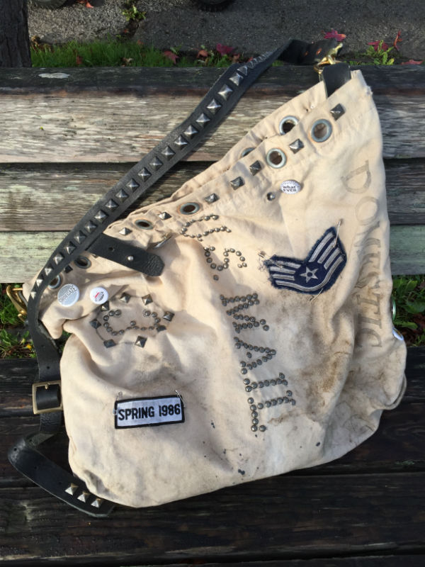 White mail bag with black studded strap