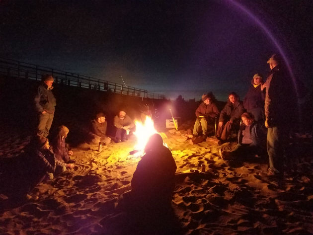 People sitting around a bonfire on a beach