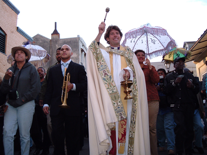 Parade led by priest in New Orleans.