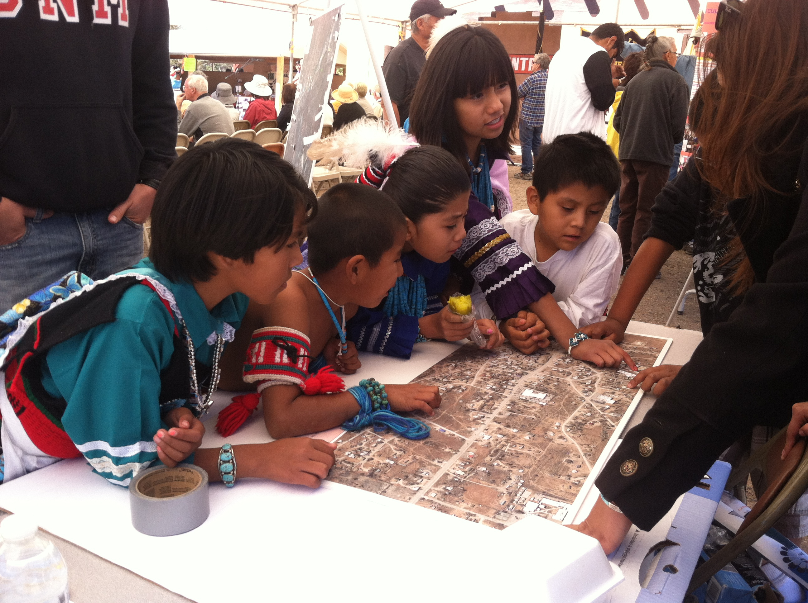 Several children looking at an aerial map. 