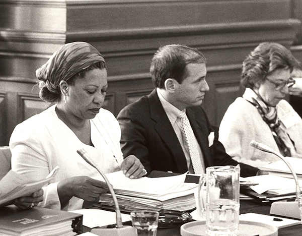 Toni Morrison going through applications, sitting at a table.