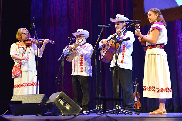 A band onstage: woman fiddler, two men guitarists, woman guitarist. 