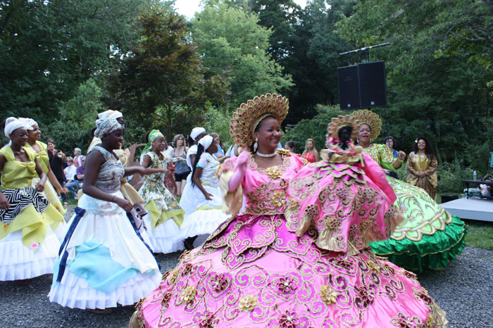 Women in colorful costumes parading down street. 