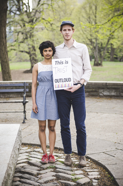 Woman and man holding a sign. 