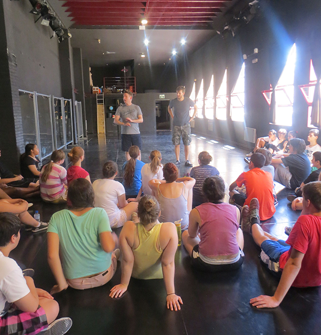 Man standing and talking to group of seated teens