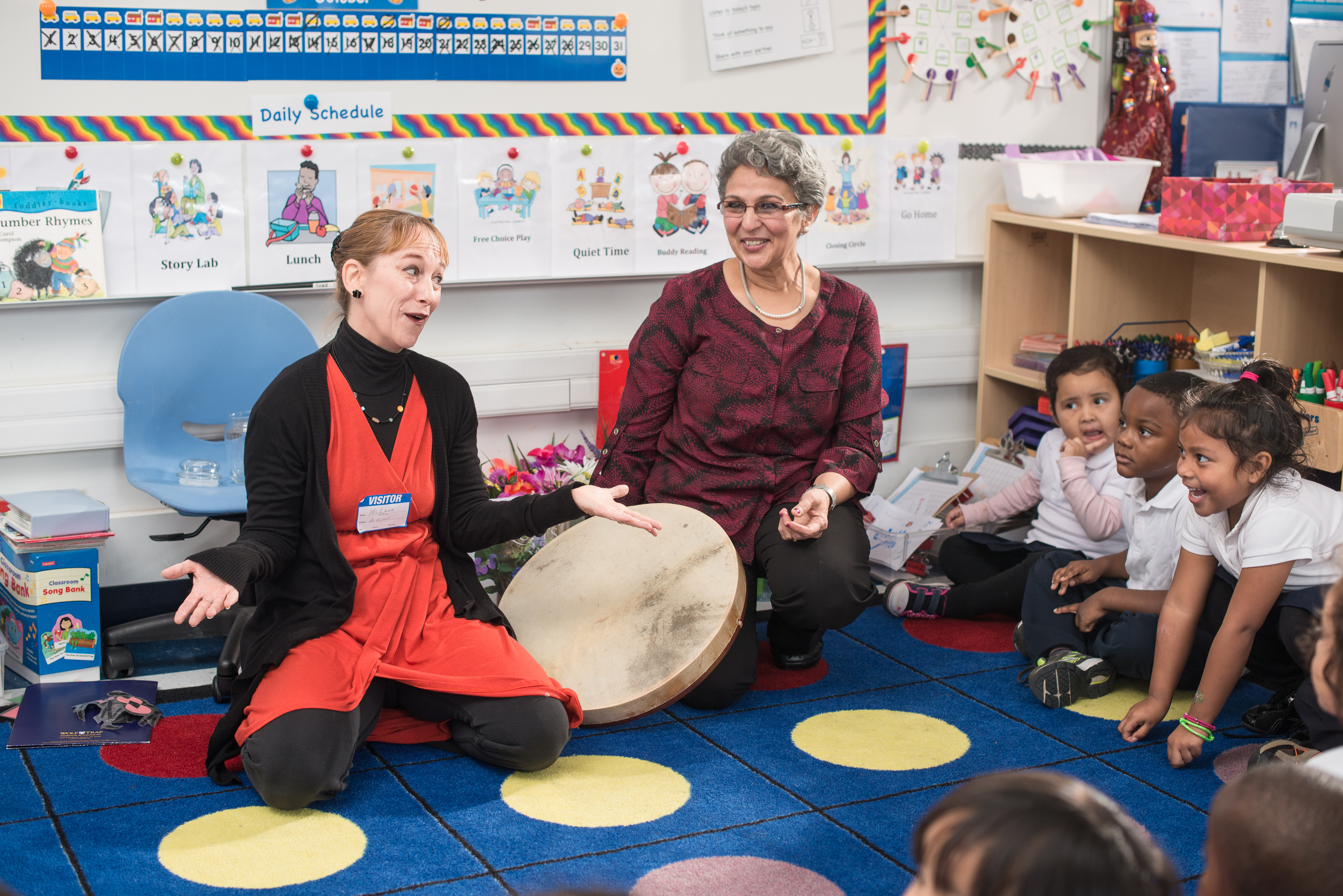 Woman in classroom of preschoolers gesturing. 