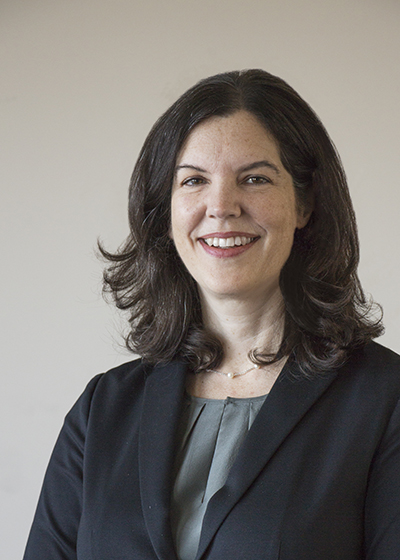 Portrait of dark-haired woman in suit.