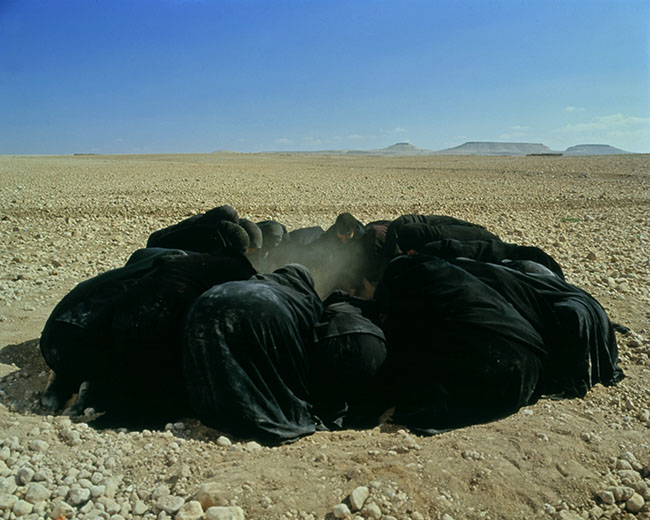 Women wearing black and crouching in circle