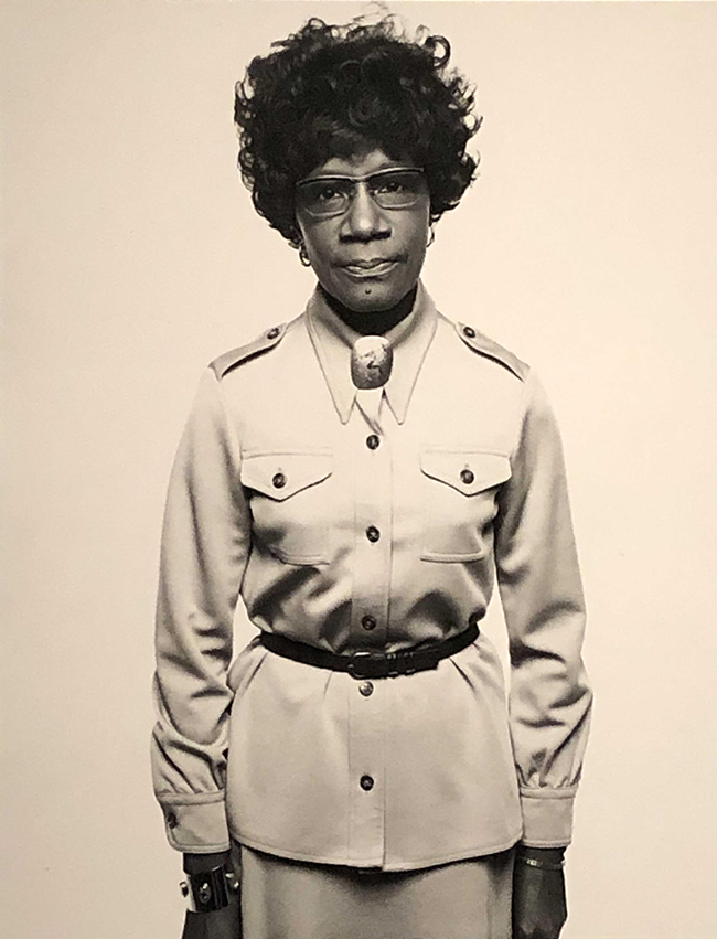 Photograph of an African American woman with glasses staring straight at camera