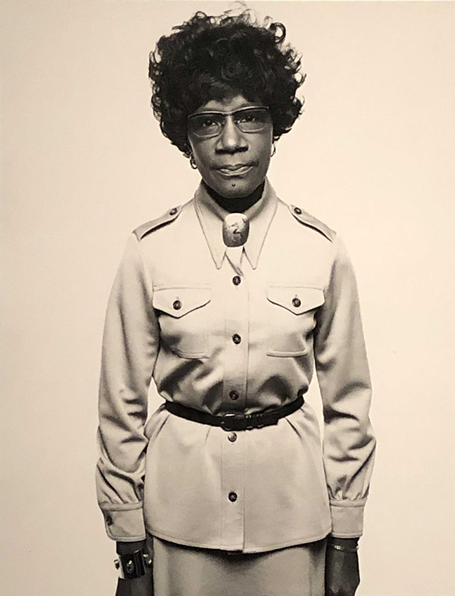 Shirley Chisholm Photograph of an African American woman with glasses staring straight at camera