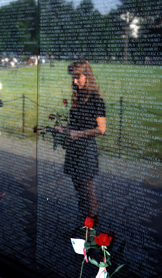 Women's reflection in front of black wall with white writing, the Vietnam Veterans Memorial Women's reflection in front of black wall with white writing, the Vietnam Veterans Memorial