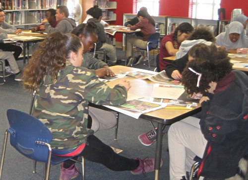 Students work at tables on art projects