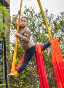 Woman performs aerial dance with long hanging silk ribbons