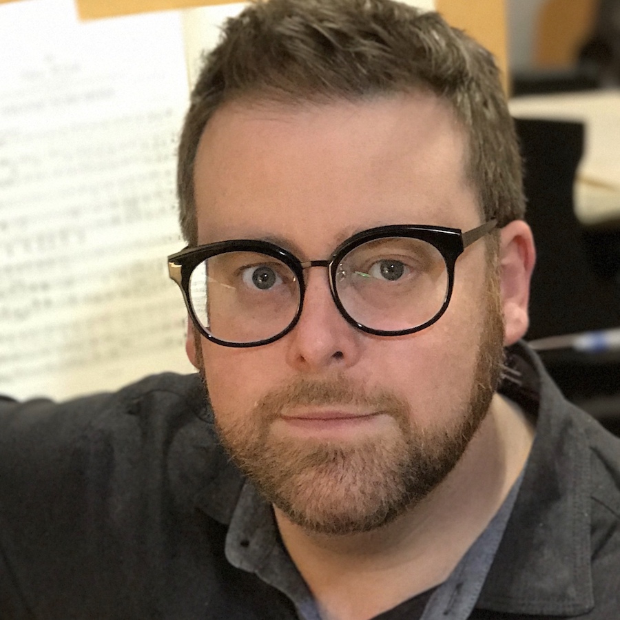 headshot of a man with glasses.