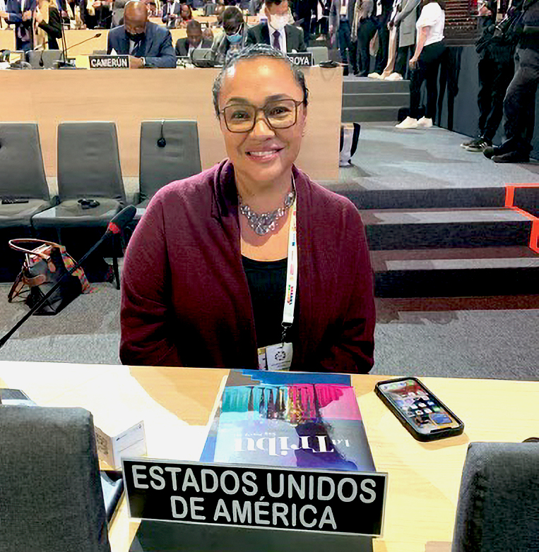 A woman sitting behind a desk looking at the camera.