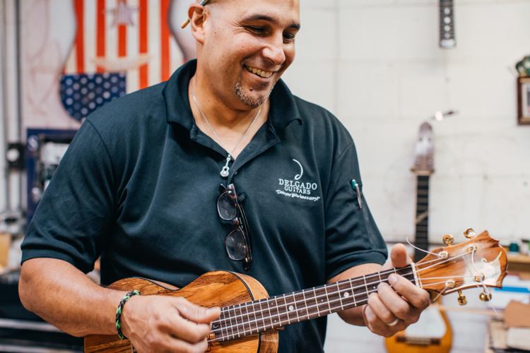 A man holding a small string instrument