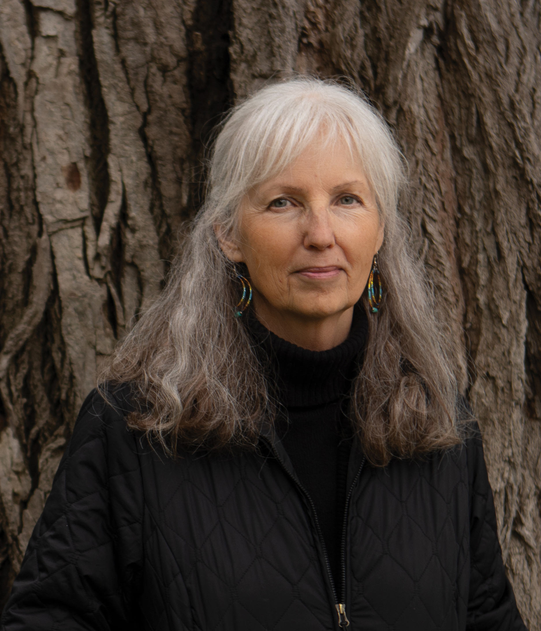 A woman in a black jacket poses