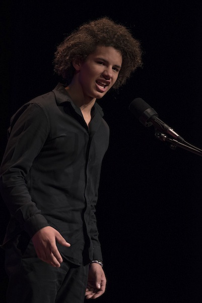 A young man on stage performing
