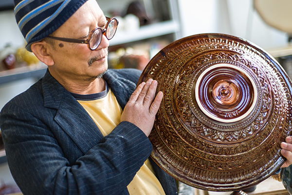 Yari Livan holding up a large ceramic work