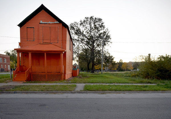 an abandoned house painted bright red-orange