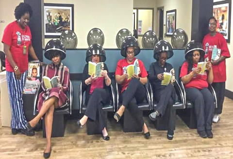 Women pose with Silver Sparrow books while under hair dryers at a salon