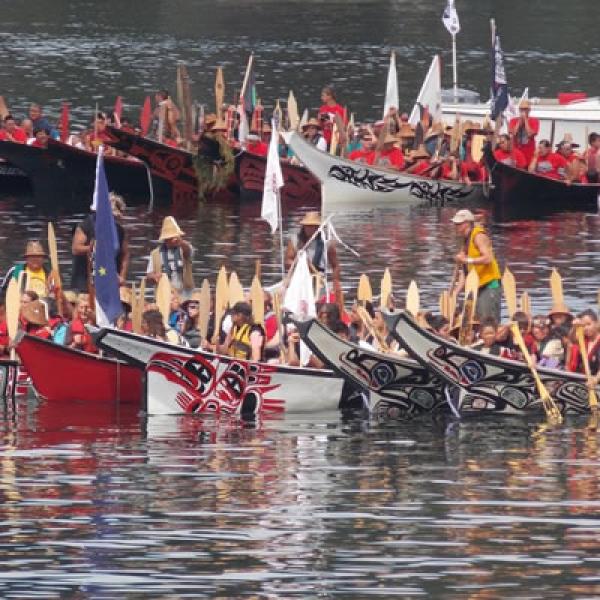 A group of canoe families conclude their journey, preparing to land on the shore of North Point in the Port of Olympia, Washington. Photo courtesy of ThurstonTalk.com