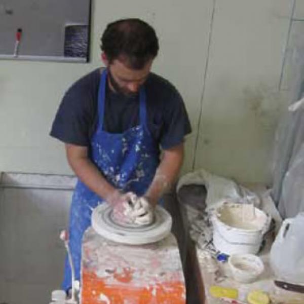 Potter William Baker shapes a new piece on the wheel in his studio; Baker is one of the local artists that North Carolina's HandMade in America has brought visibility to with its guidebooks and online resources.