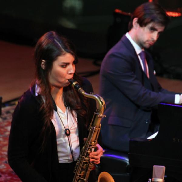 Woman playing saxophone in concert.