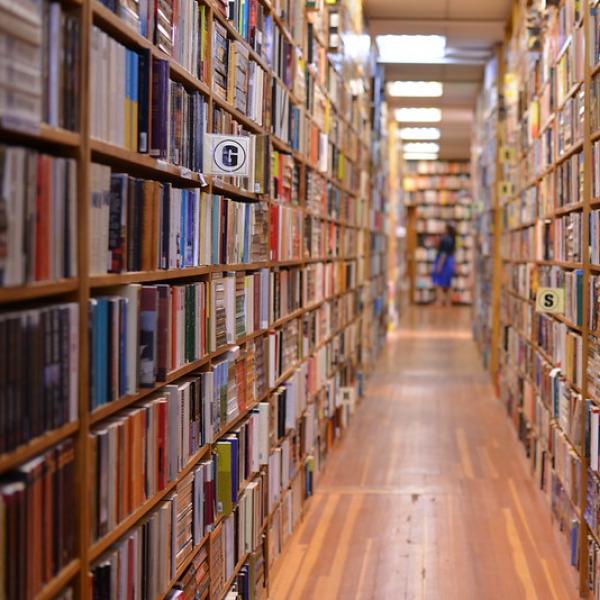 A photo that looks down the aisle of shelves in a bookstore