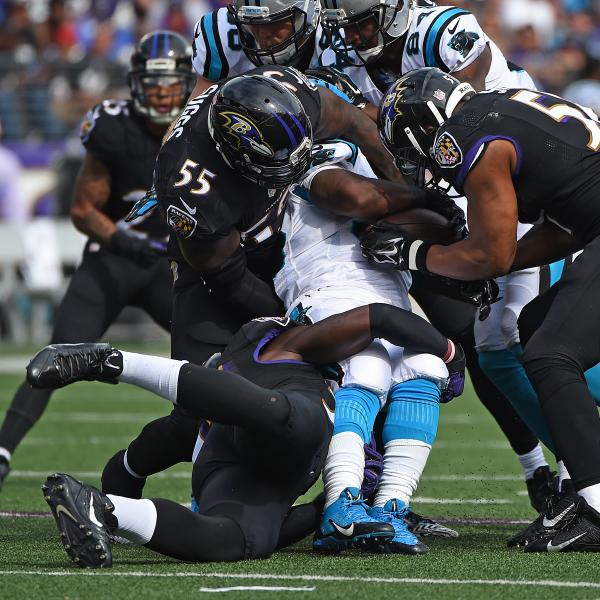 Football players tackling one another.
