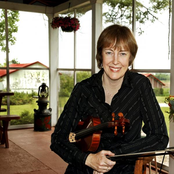 Woman in suit holding a fiddle. 