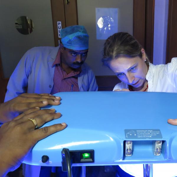 Woman and man looking at phototherapy machinery.