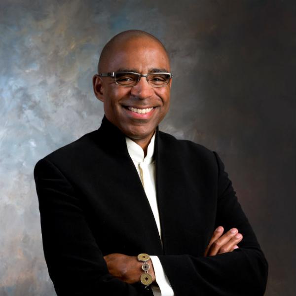 Smiling African-American man standing with arms crossed