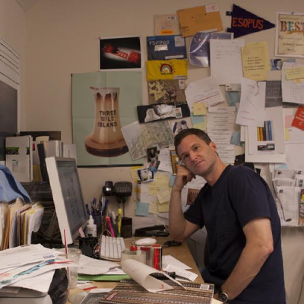 Man sitting at desk in messy office. 