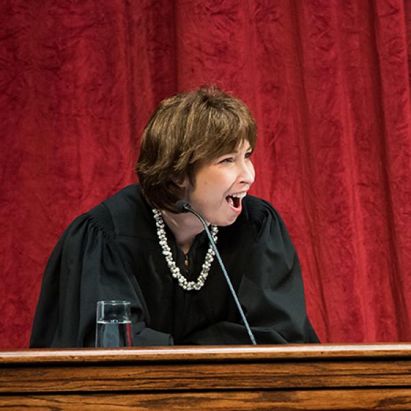 Female judge sitting behind podium.