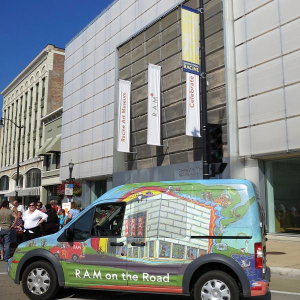 A colorful bus parked in front of a museum. 