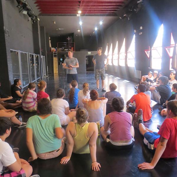 Man standing and talking to group of seated teens