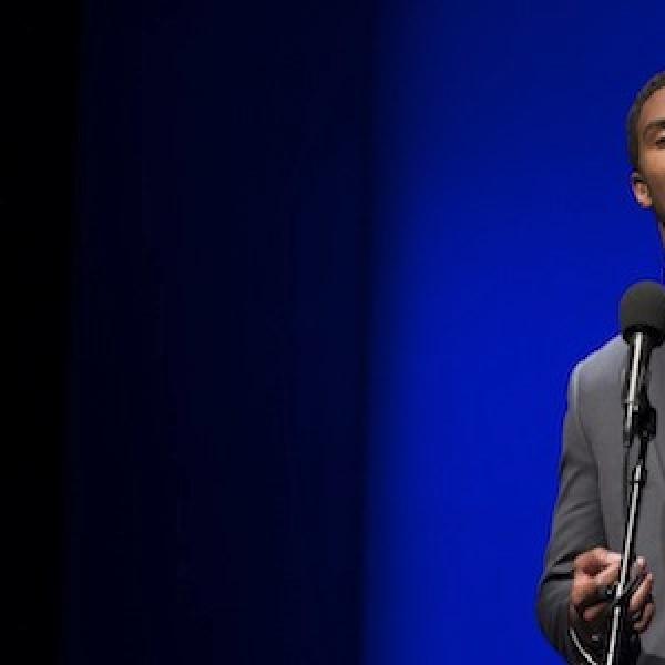 Young African-American reciting poetry in front of mike.