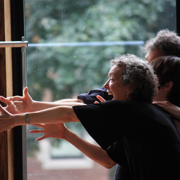 Three men and women outstretch their arms and give big smiles