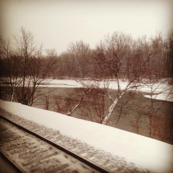 Railroad tracks photo taken from inside of train out the window.